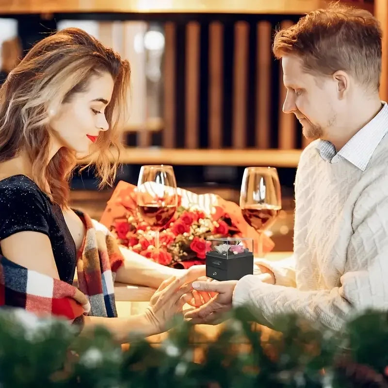 Romantic dinner with wine, roses, and a gift box for a special occasion