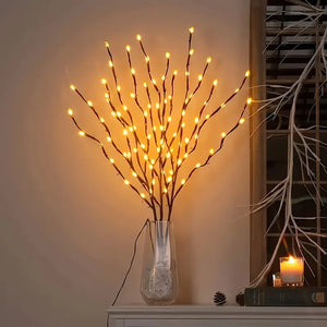 Decorative lighting branch with lights in a vase on a shelf.