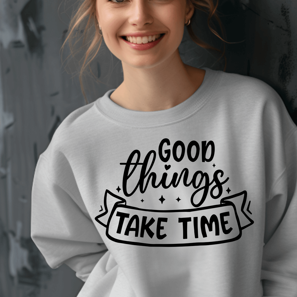 Person wearing a gray sweatshirt with 'Good things take time' text design.