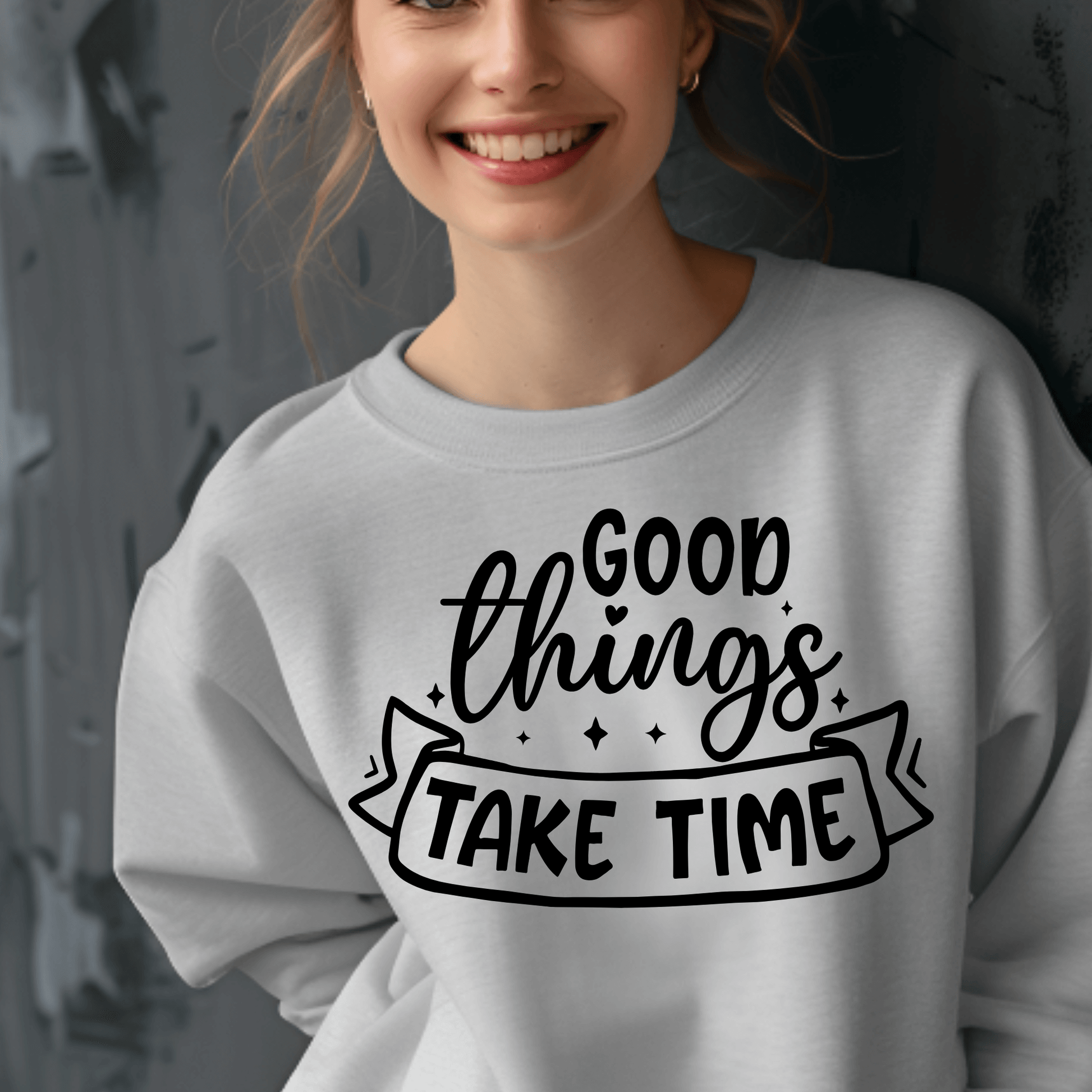Person wearing a gray sweatshirt with 'Good things take time' text design.