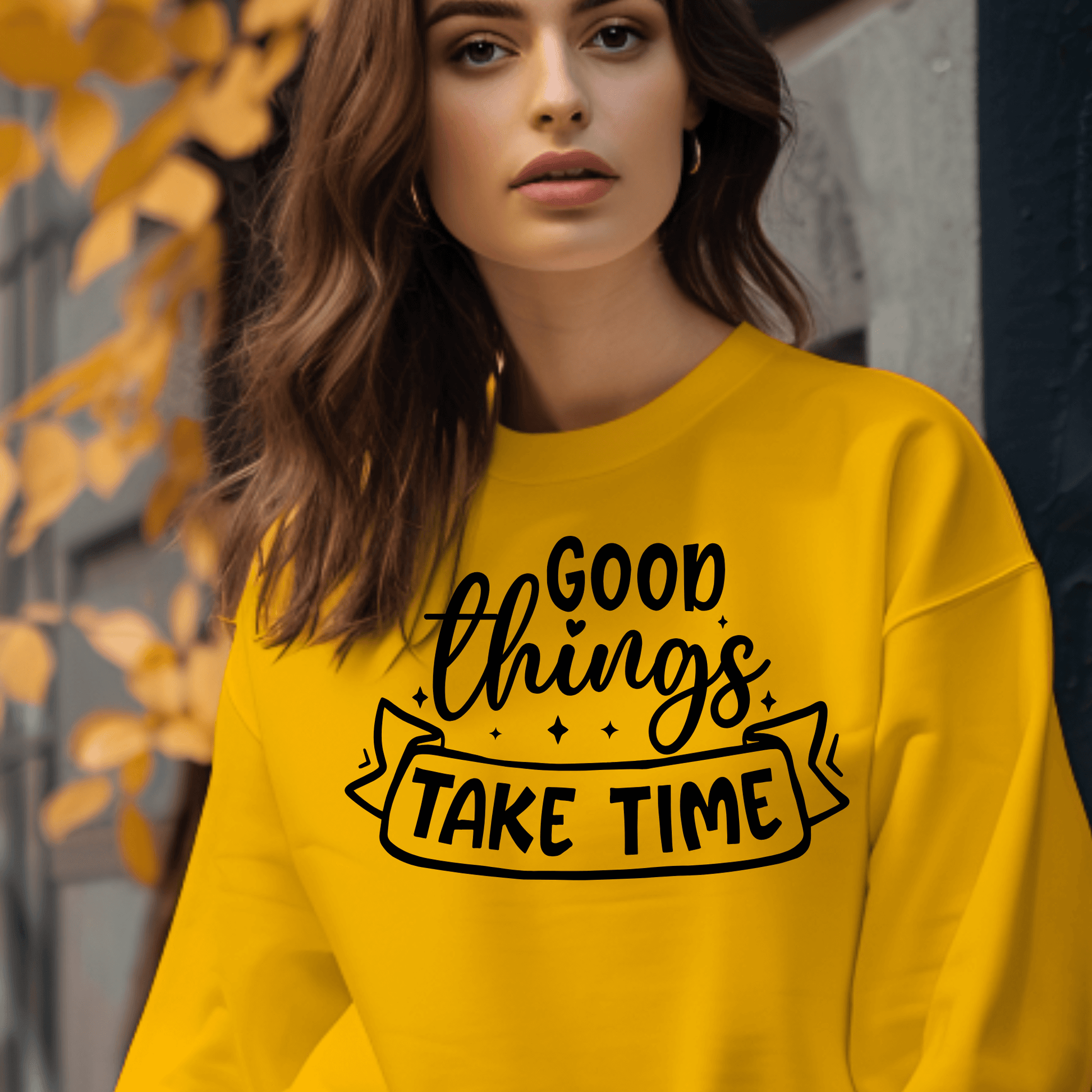 Woman wearing a yellow sweatshirt with 'Good things take time' text.