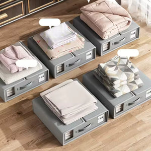 Gray storage boxes with folded clothes on a wooden floor