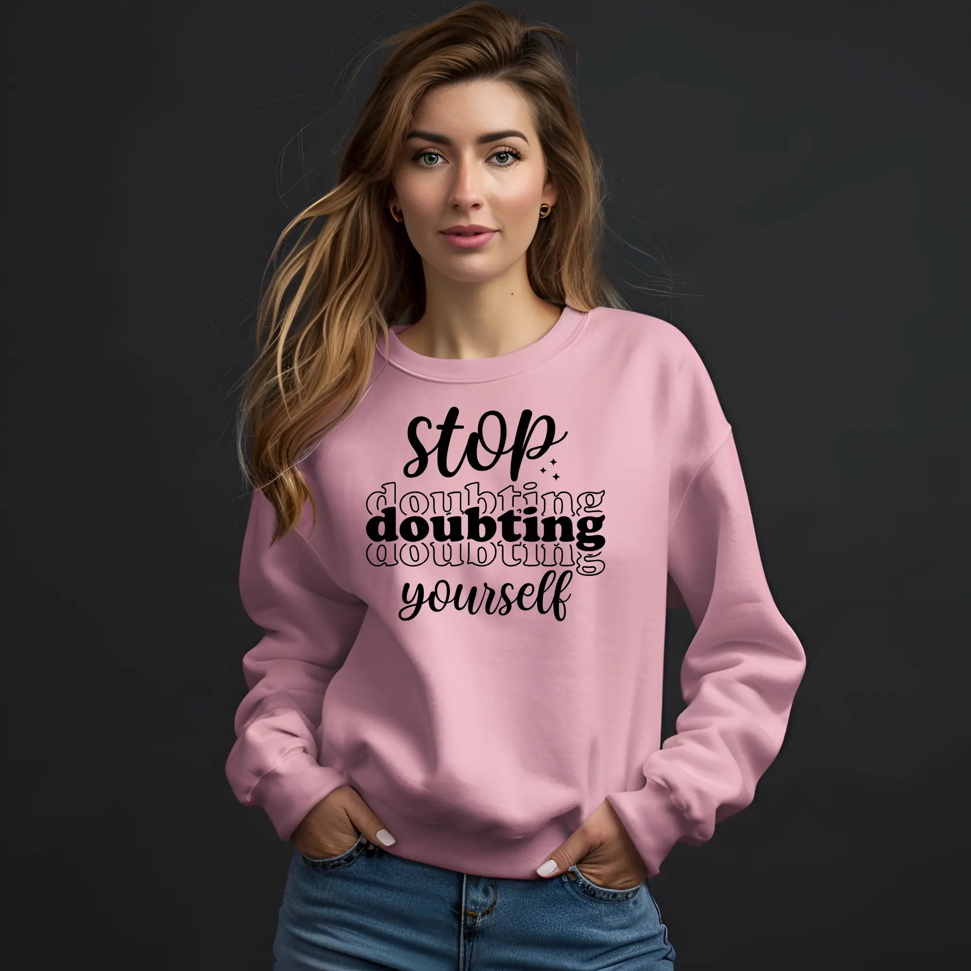 Woman wearing a pink sweatshirt with motivational text on a black background