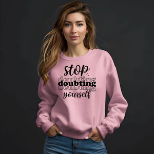 Woman wearing a pink sweatshirt with motivational text on a black background