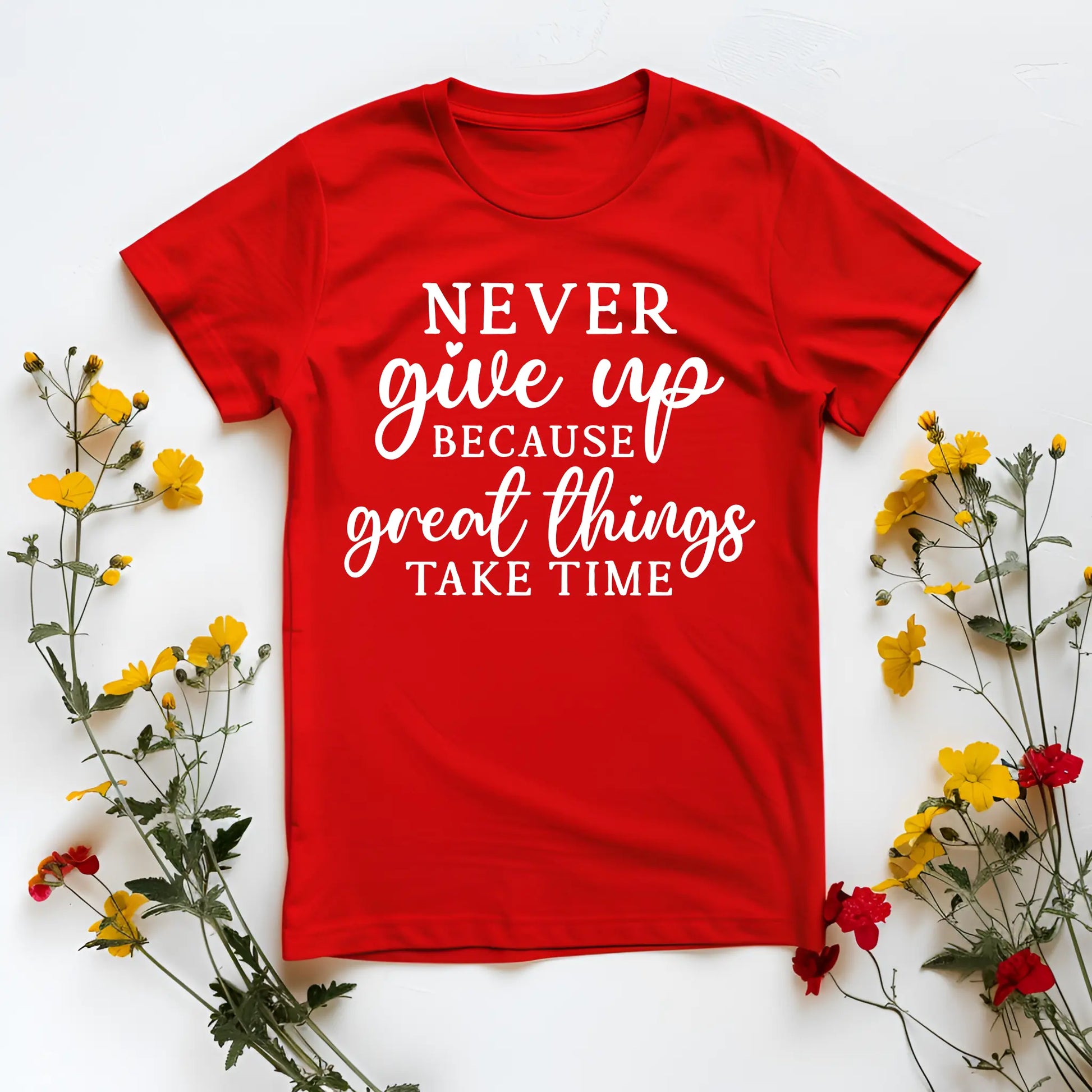 Red t-shirt with motivational quote surrounded by yellow and red flowers on a white background