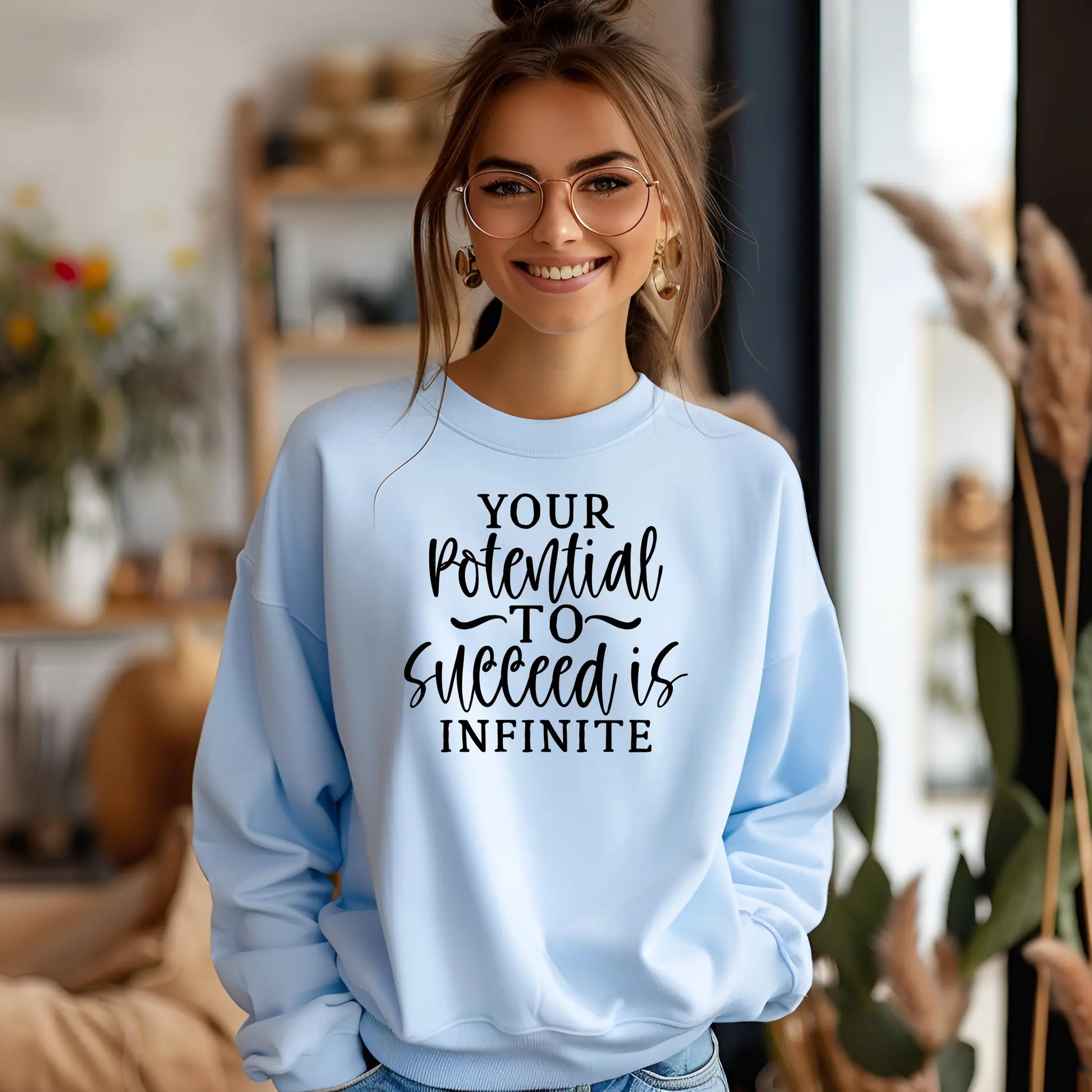 Woman wearing a light blue sweatshirt with motivational text in a home setting