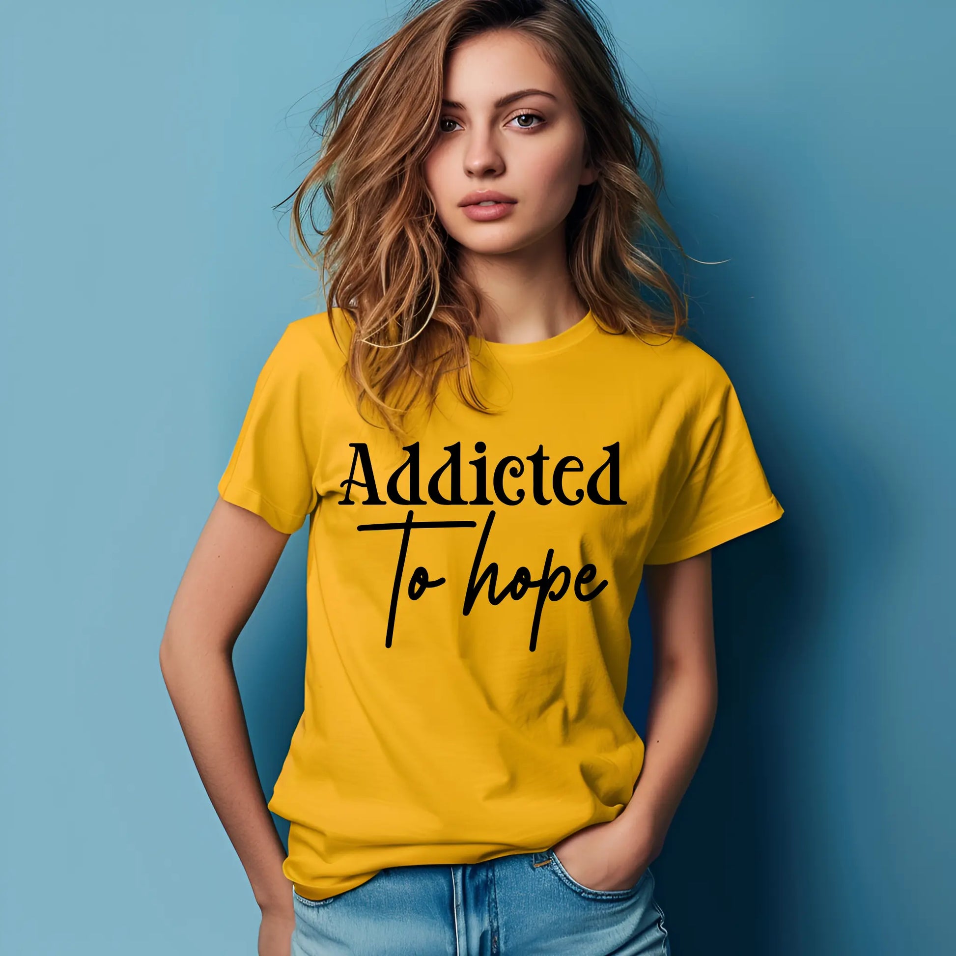 Woman wearing a yellow t-shirt with 'Addicted To Hope' text against a blue background