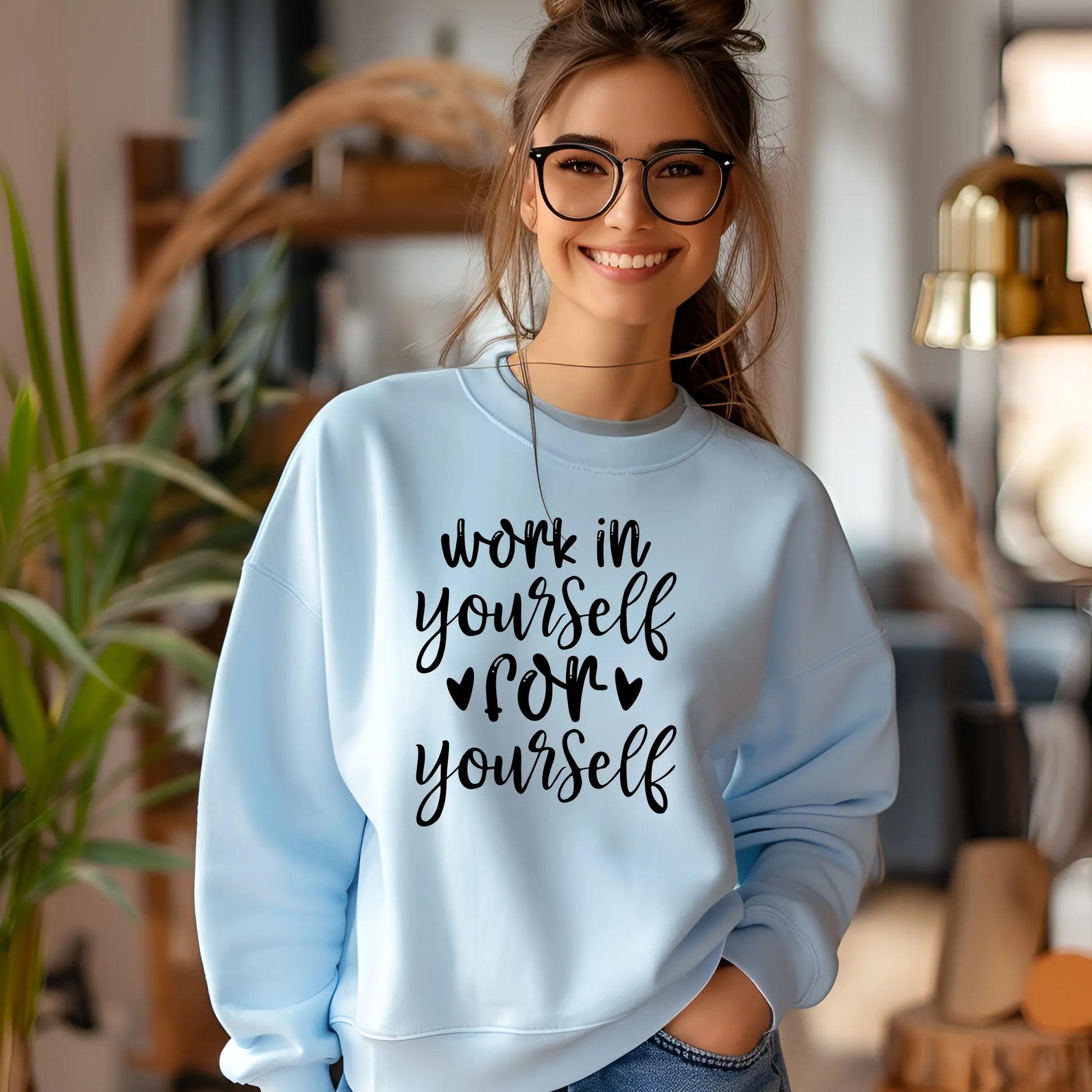 Woman wearing a light blue sweatshirt with text in a home setting