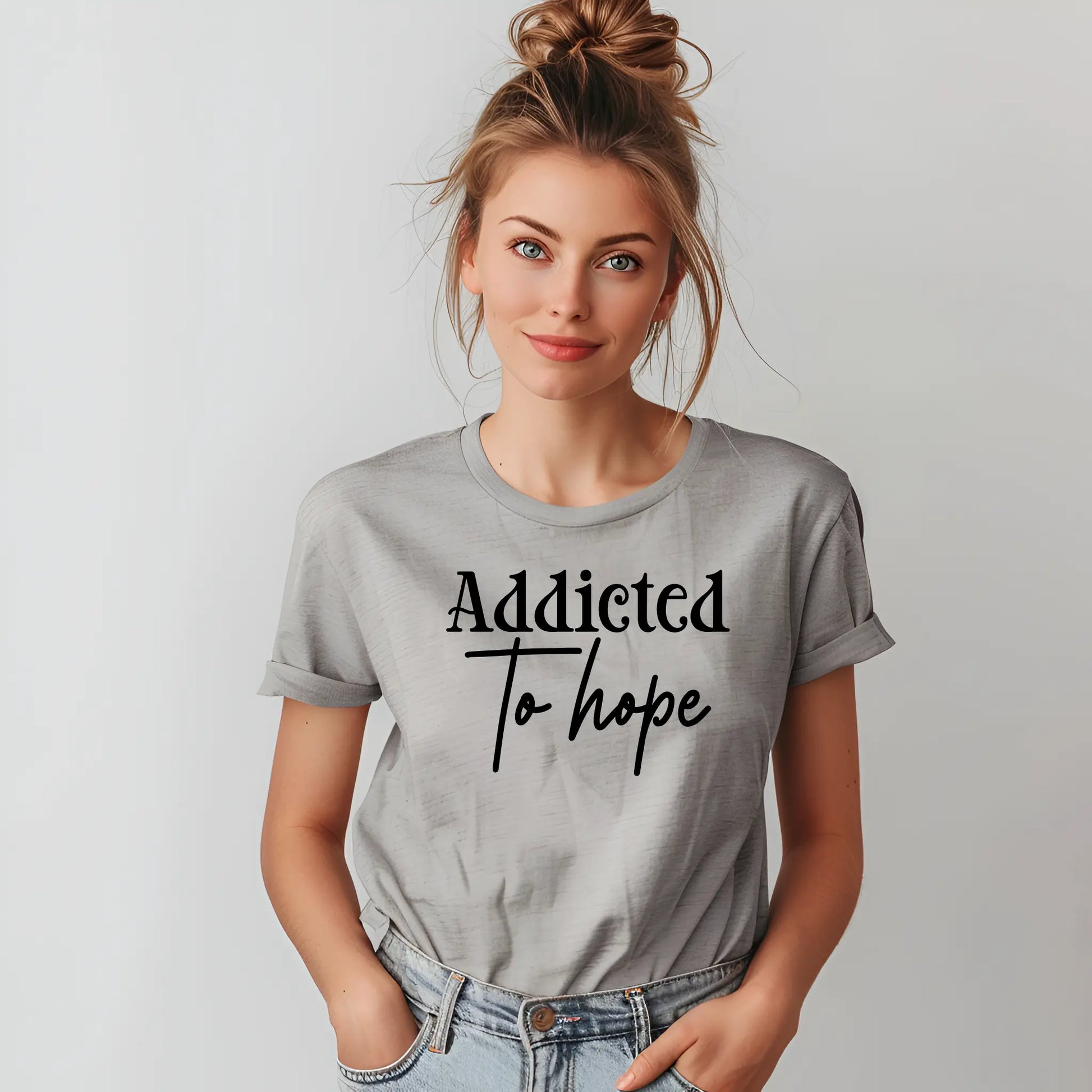 Woman wearing a gray t-shirt with 'Addicted To Hope' text on a plain background