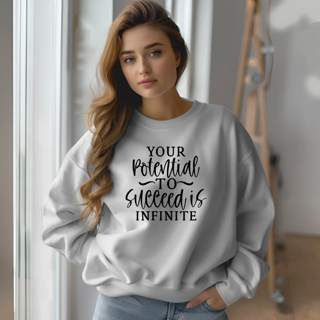 Woman wearing a white sweatshirt with motivational text in a casual setting