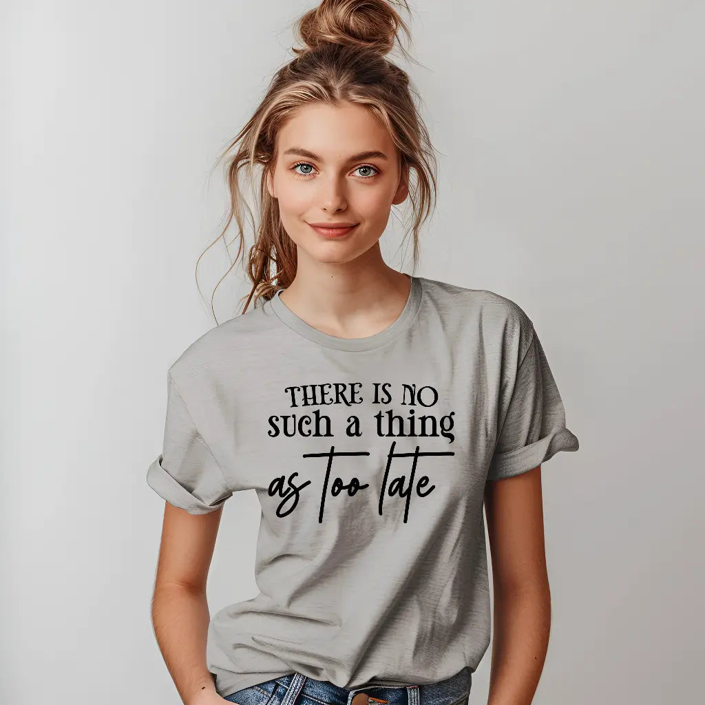 Woman wearing a gray t-shirt with motivational text on a plain background