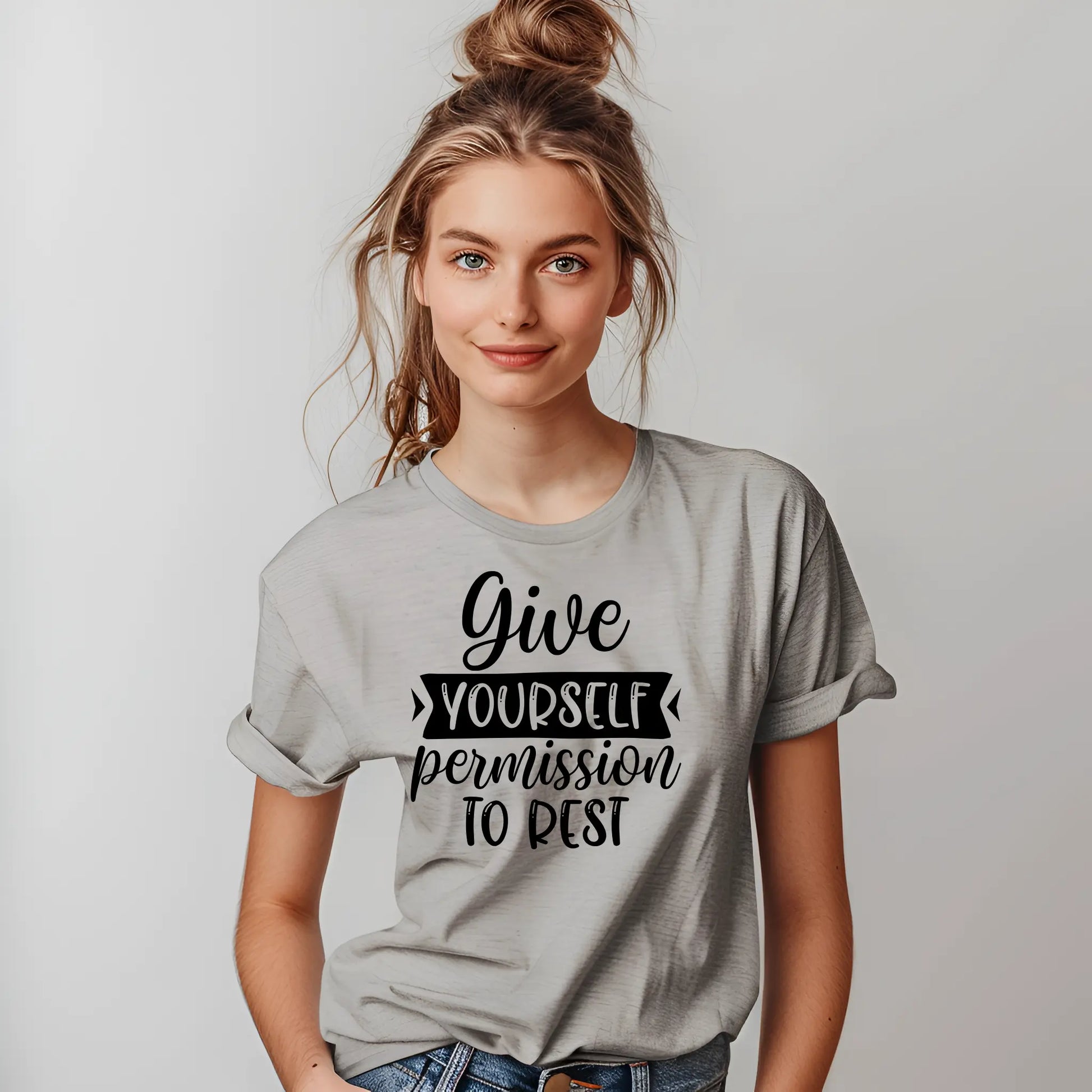 Person wearing a gray t-shirt with motivational text on a plain background
