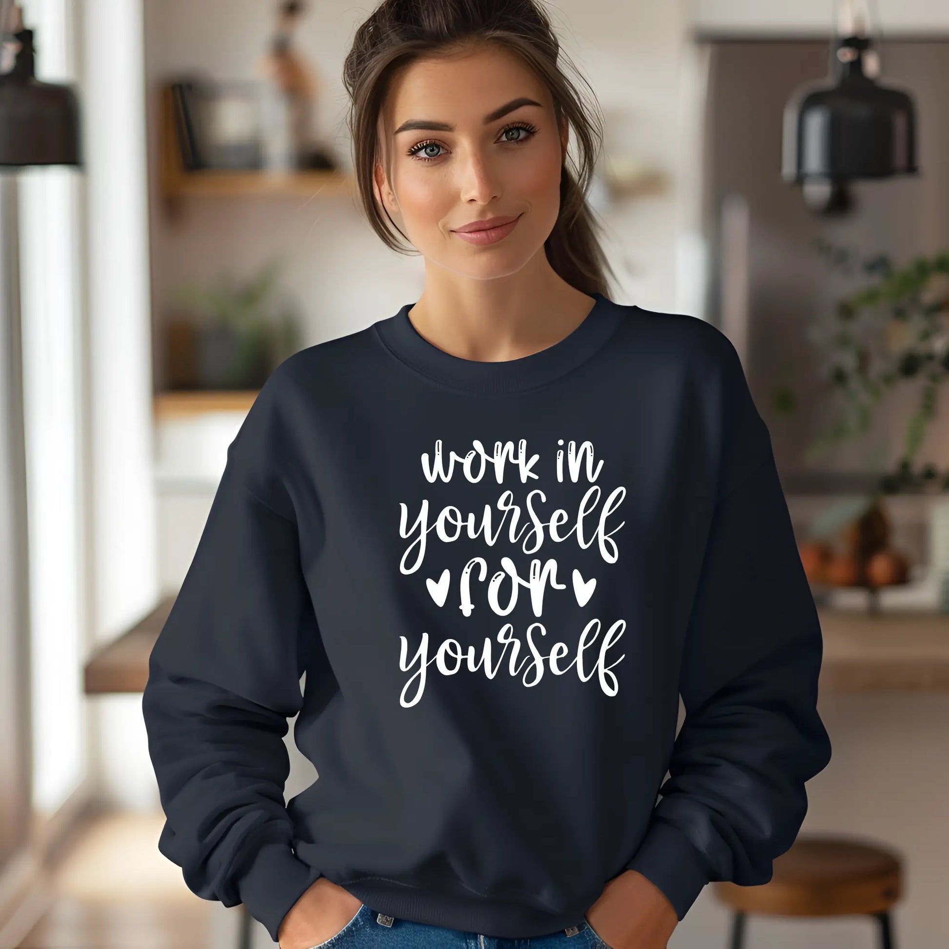 Woman wearing a navy blue sweatshirt with motivational text in a casual setting