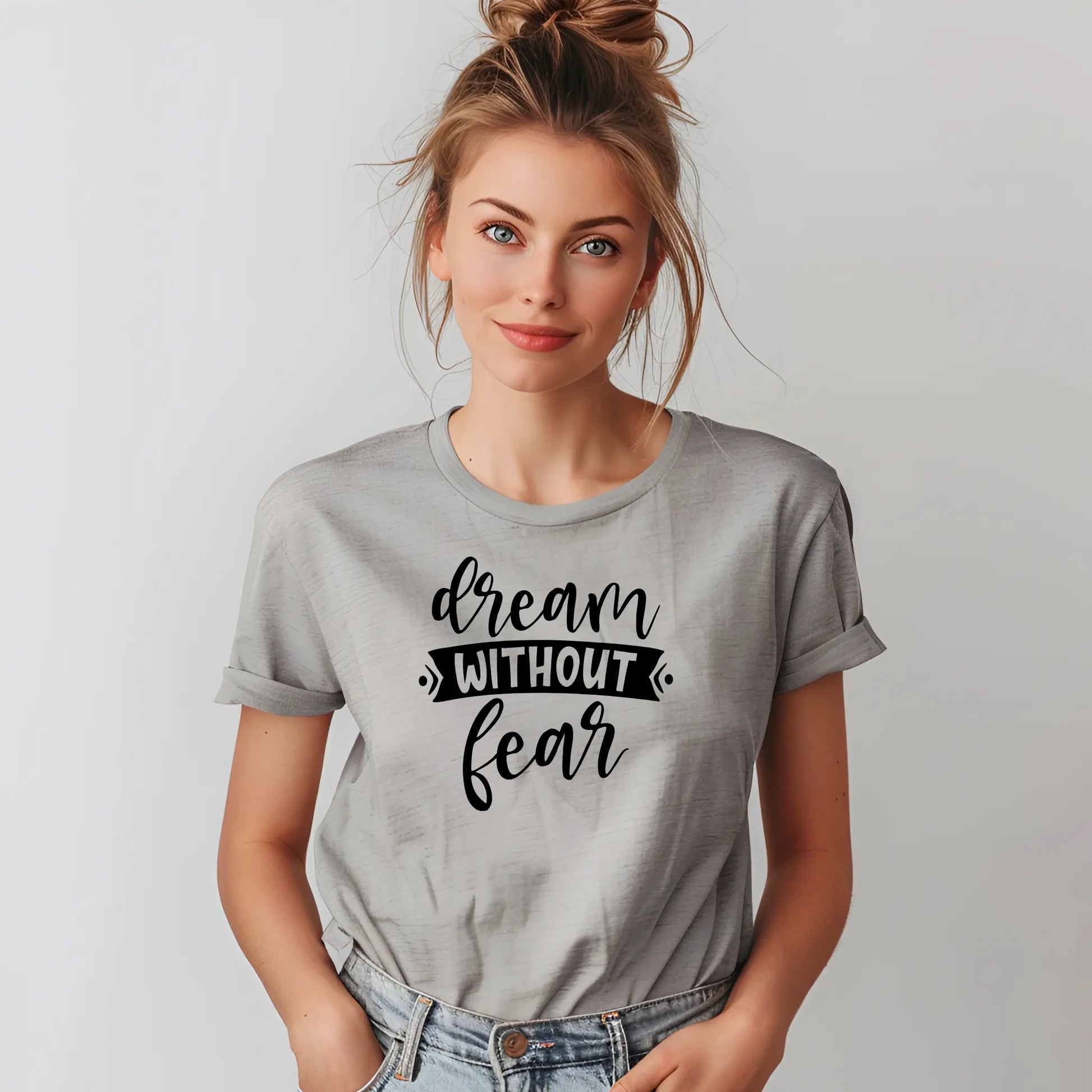 Woman wearing a gray t-shirt with 'dream without fear' text on a plain background