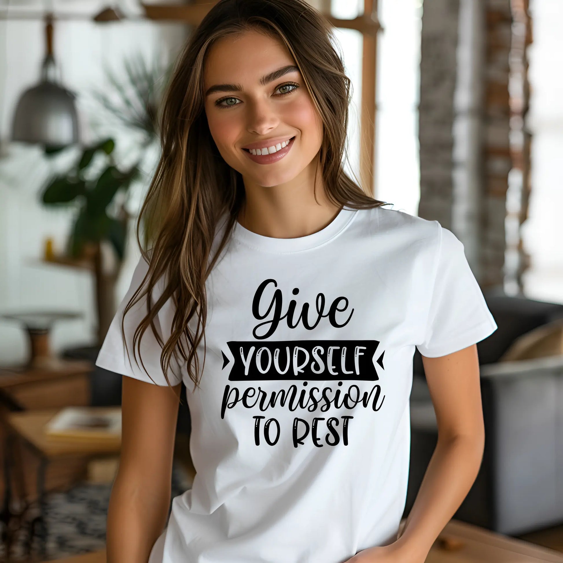 Woman wearing a white t-shirt with motivational text in a casual indoor setting