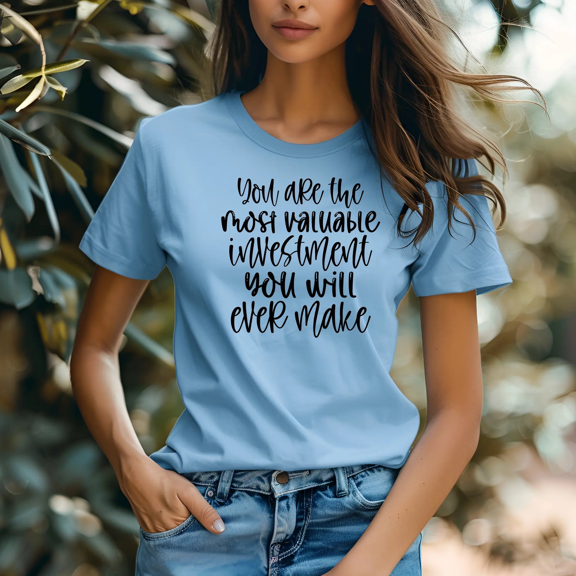 Person wearing a light blue t-shirt with motivational quote outdoors
