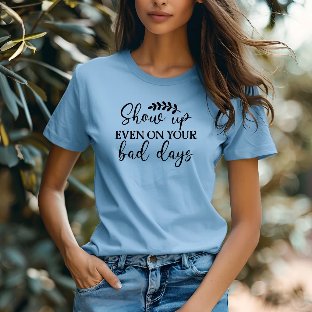 Person wearing a blue t-shirt with motivational text in an outdoor setting