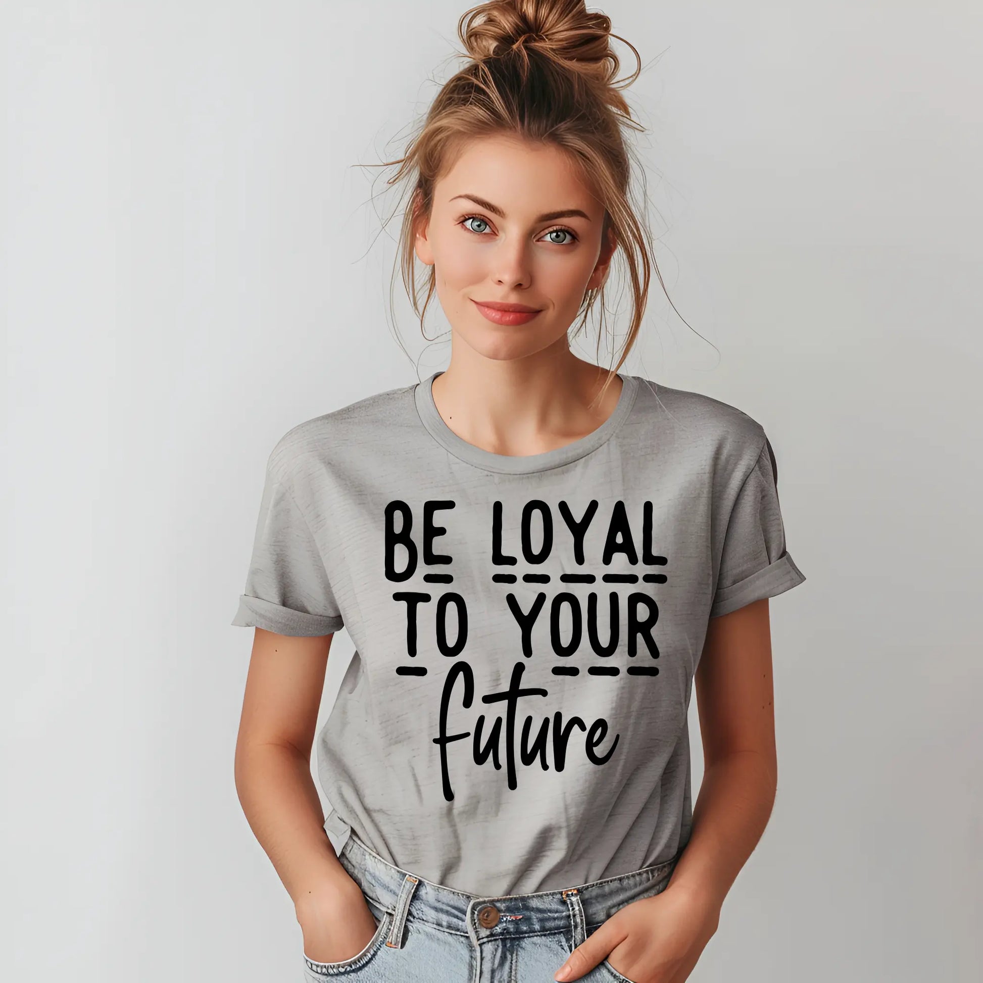 Woman wearing a gray t-shirt with 'Be Loyal To Your Future' text on a plain background
