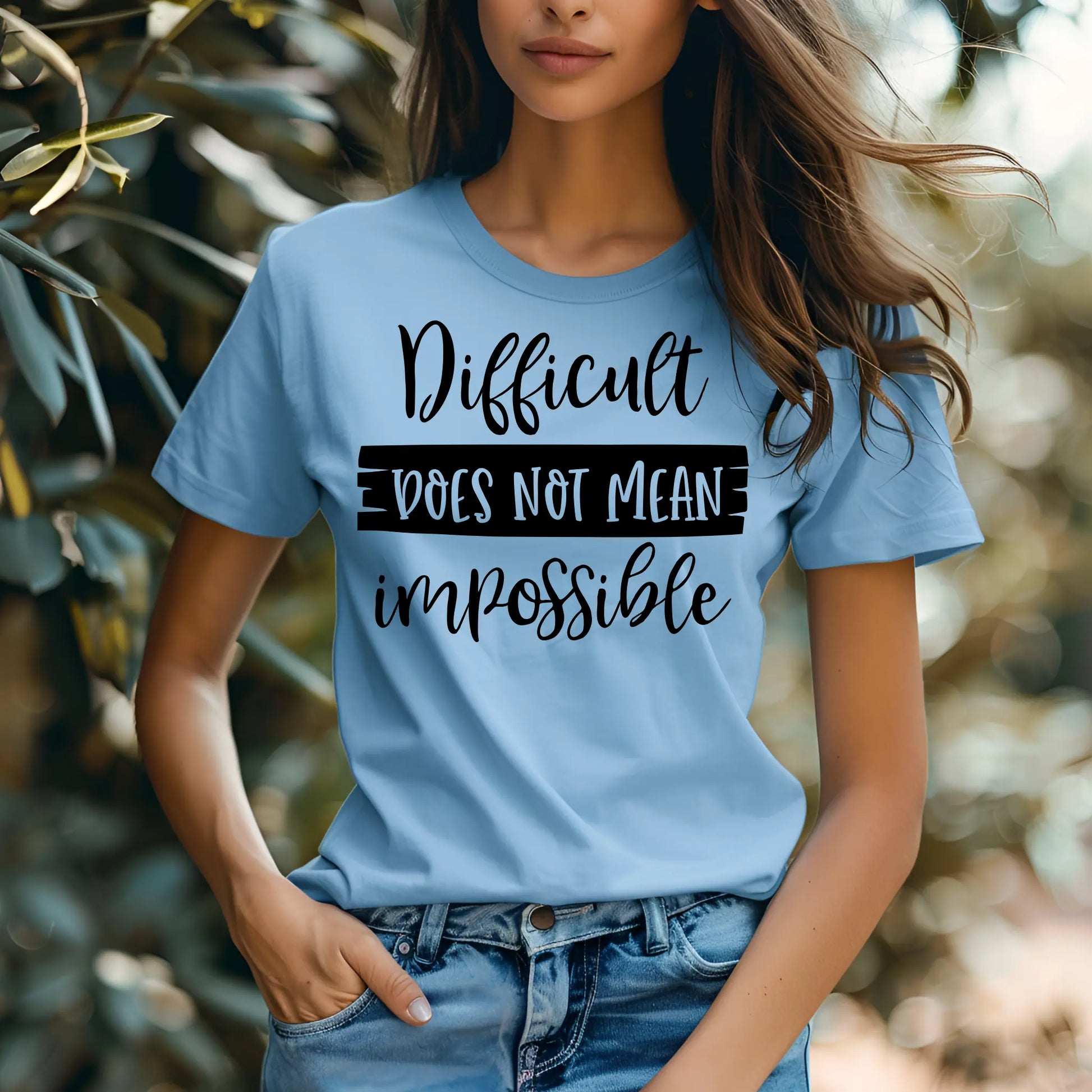 Person wearing a blue t-shirt with motivational text in an outdoor setting