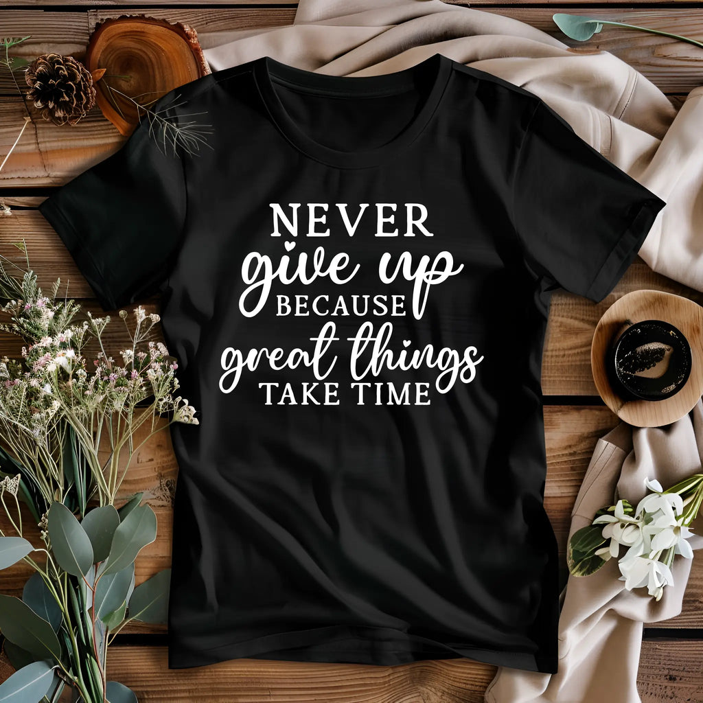 Black t-shirt with motivational quote on a wooden surface with decorative elements