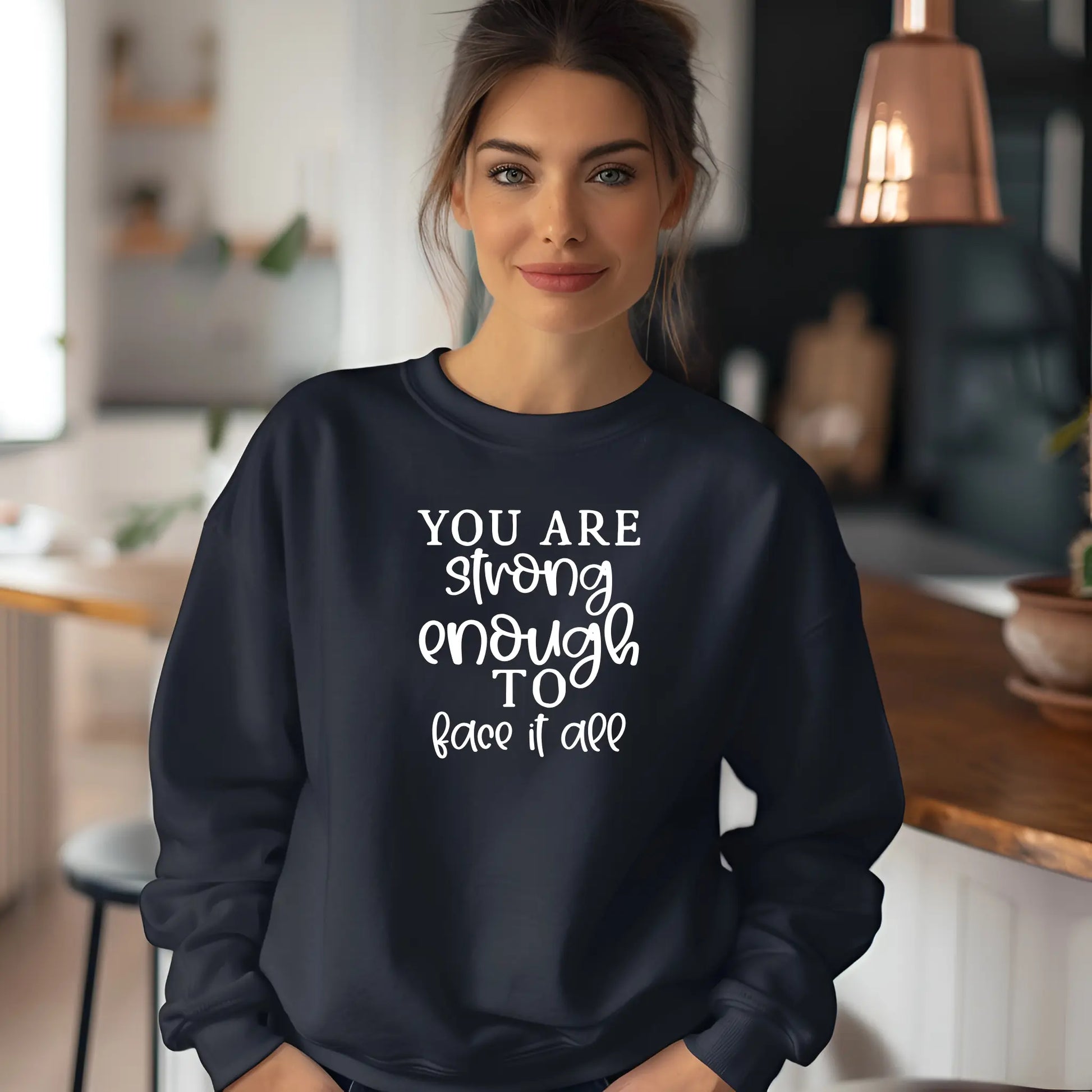 Woman wearing a navy sweatshirt with motivational quote in a kitchen setting