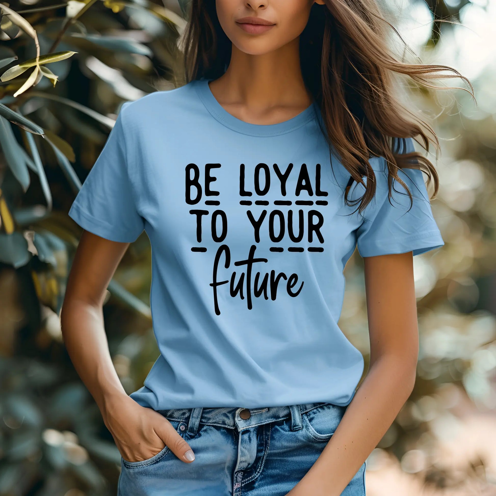Person wearing a blue t-shirt with 'Be loyal to your future' text outdoors.