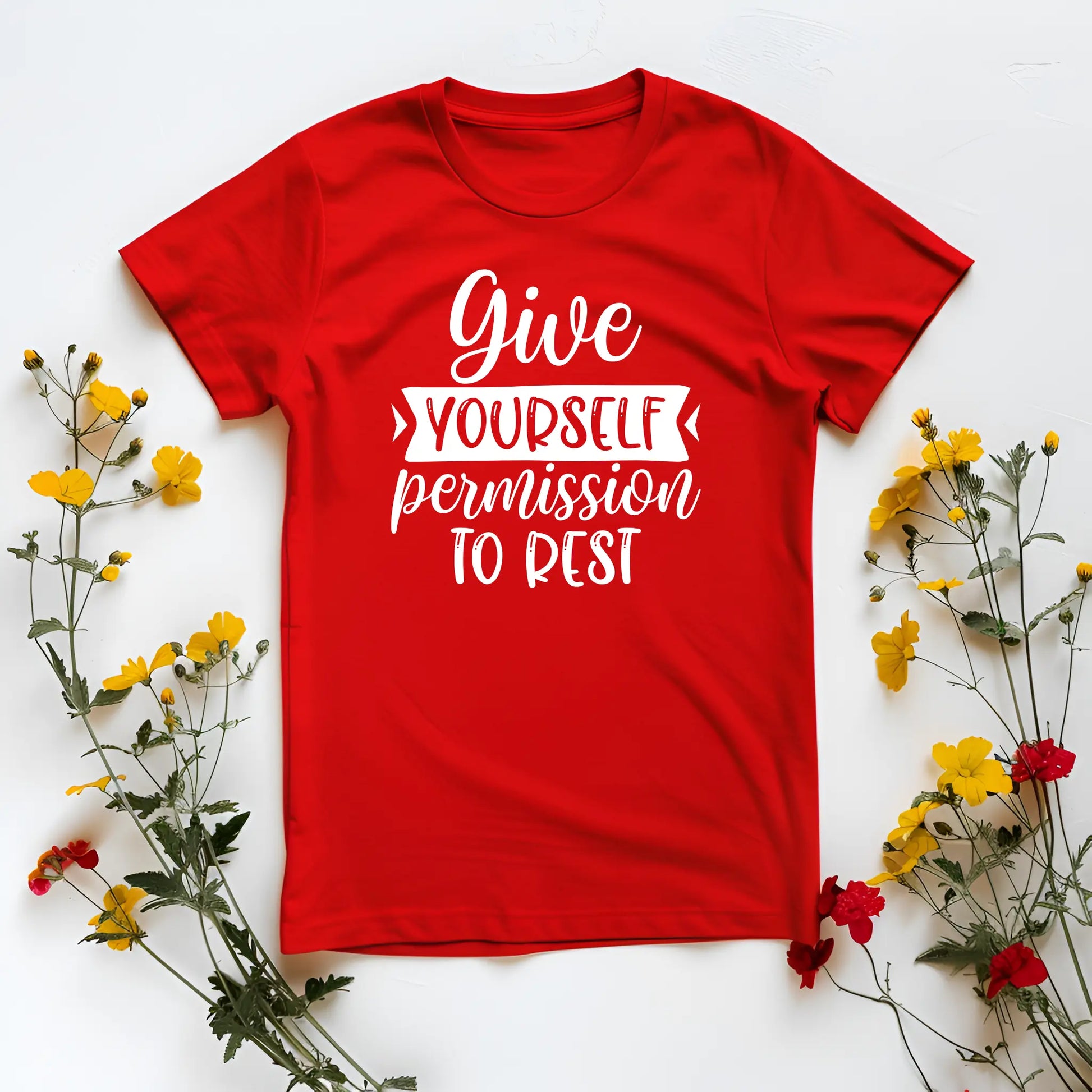 Red t-shirt with motivational quote surrounded by flowers on a white background