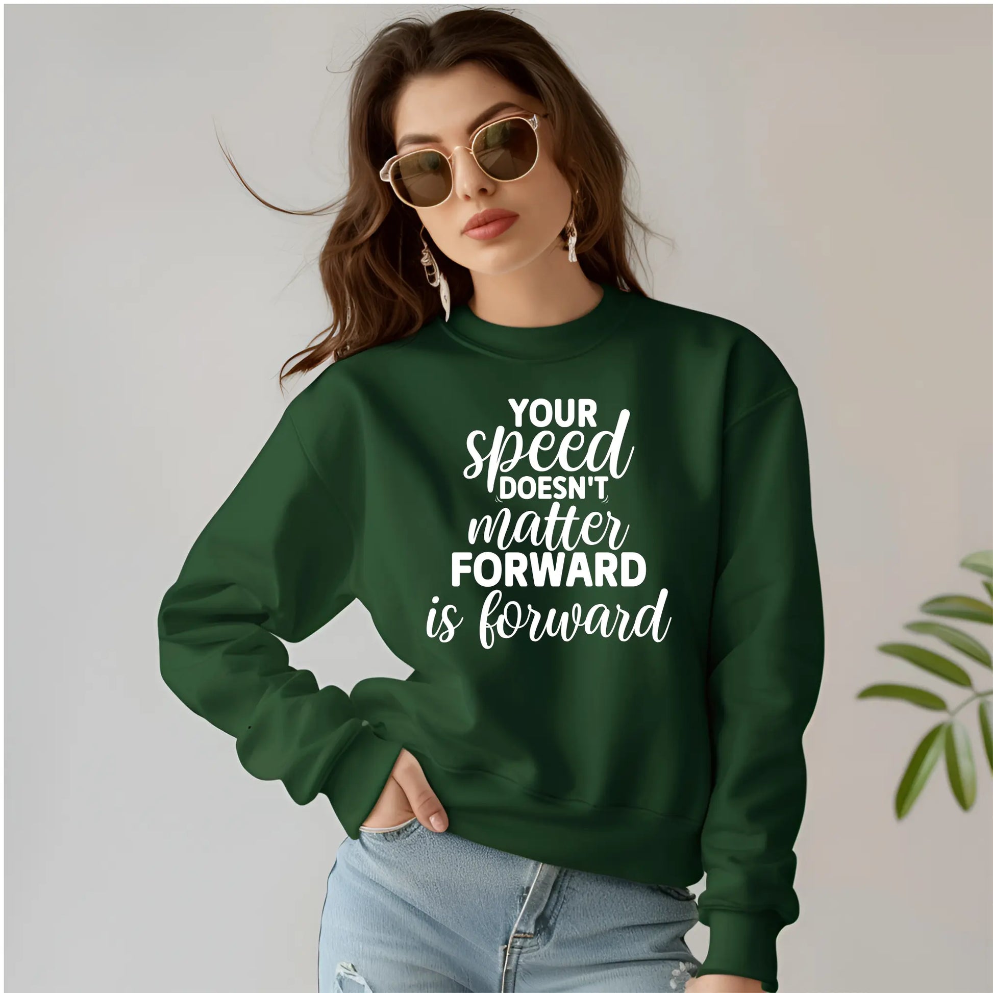 Person wearing a green sweatshirt with motivational text on a plain background