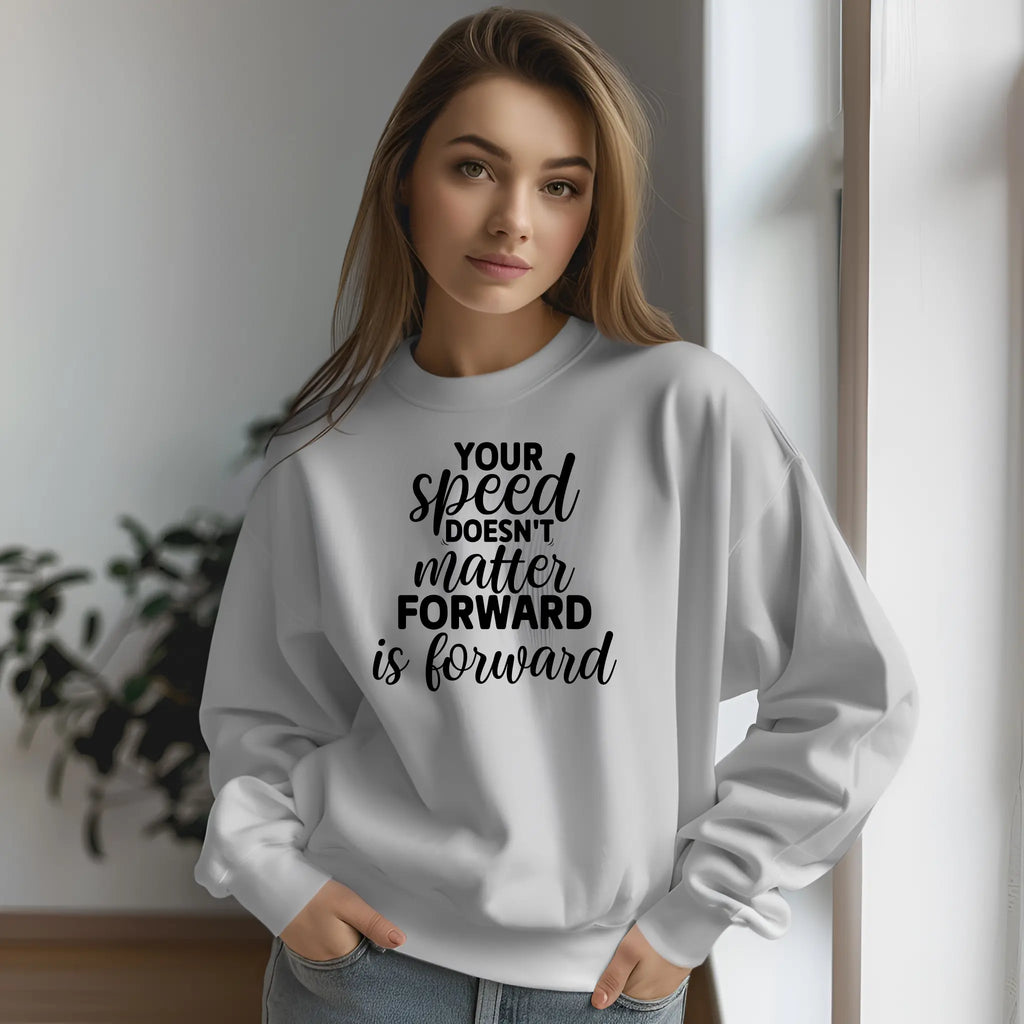 Woman wearing a white sweatshirt with a motivational quote indoors.